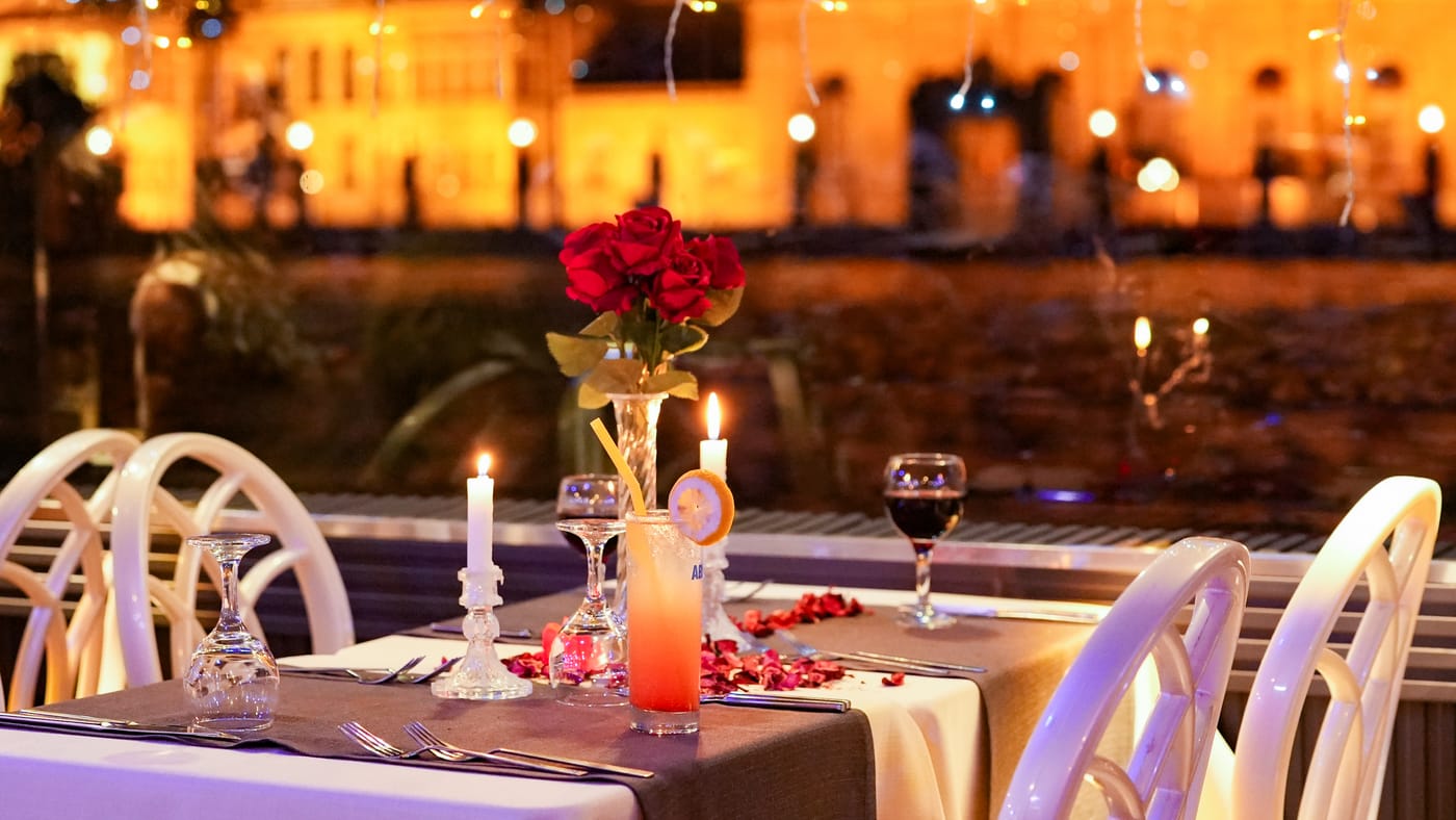 Candles and rose petals on a window table at night