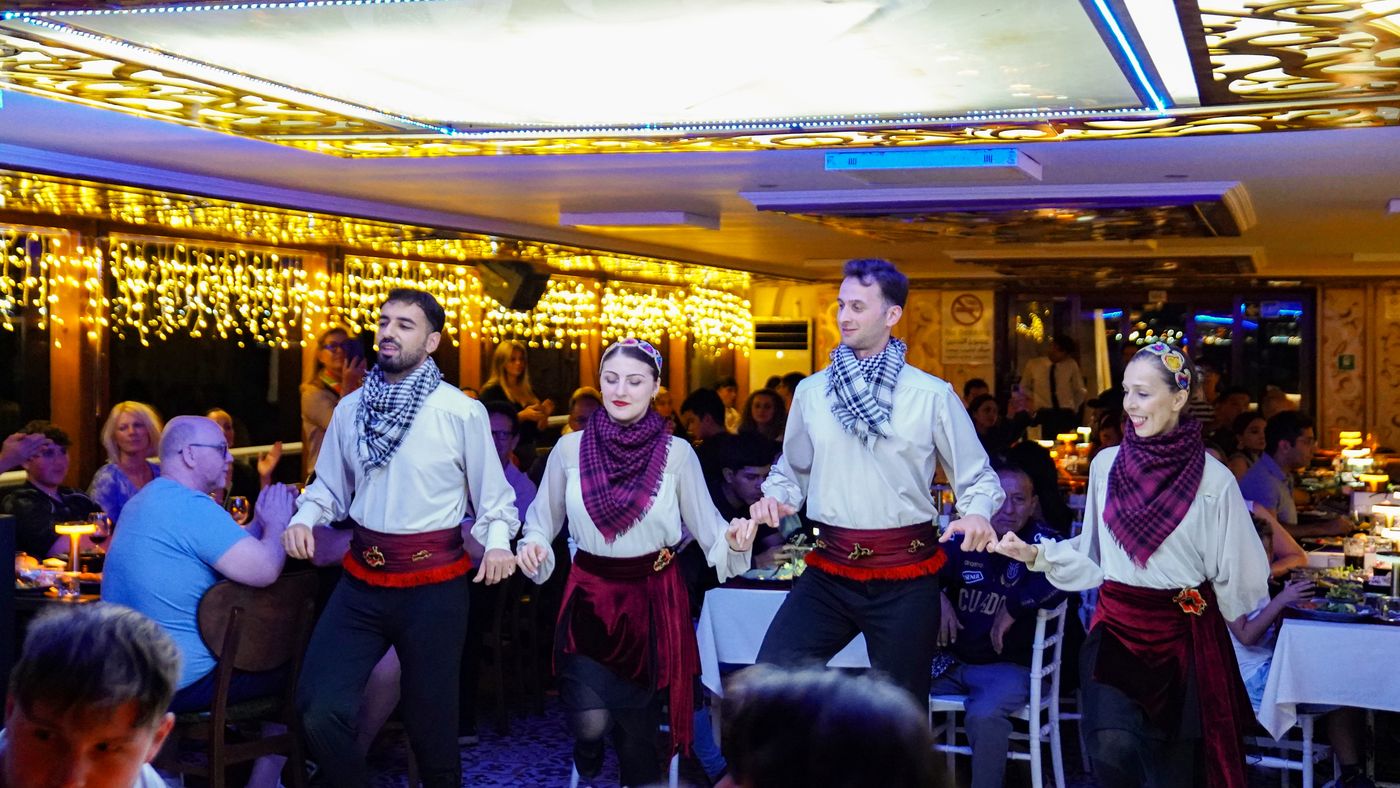 Folk dancers link hands along the tables