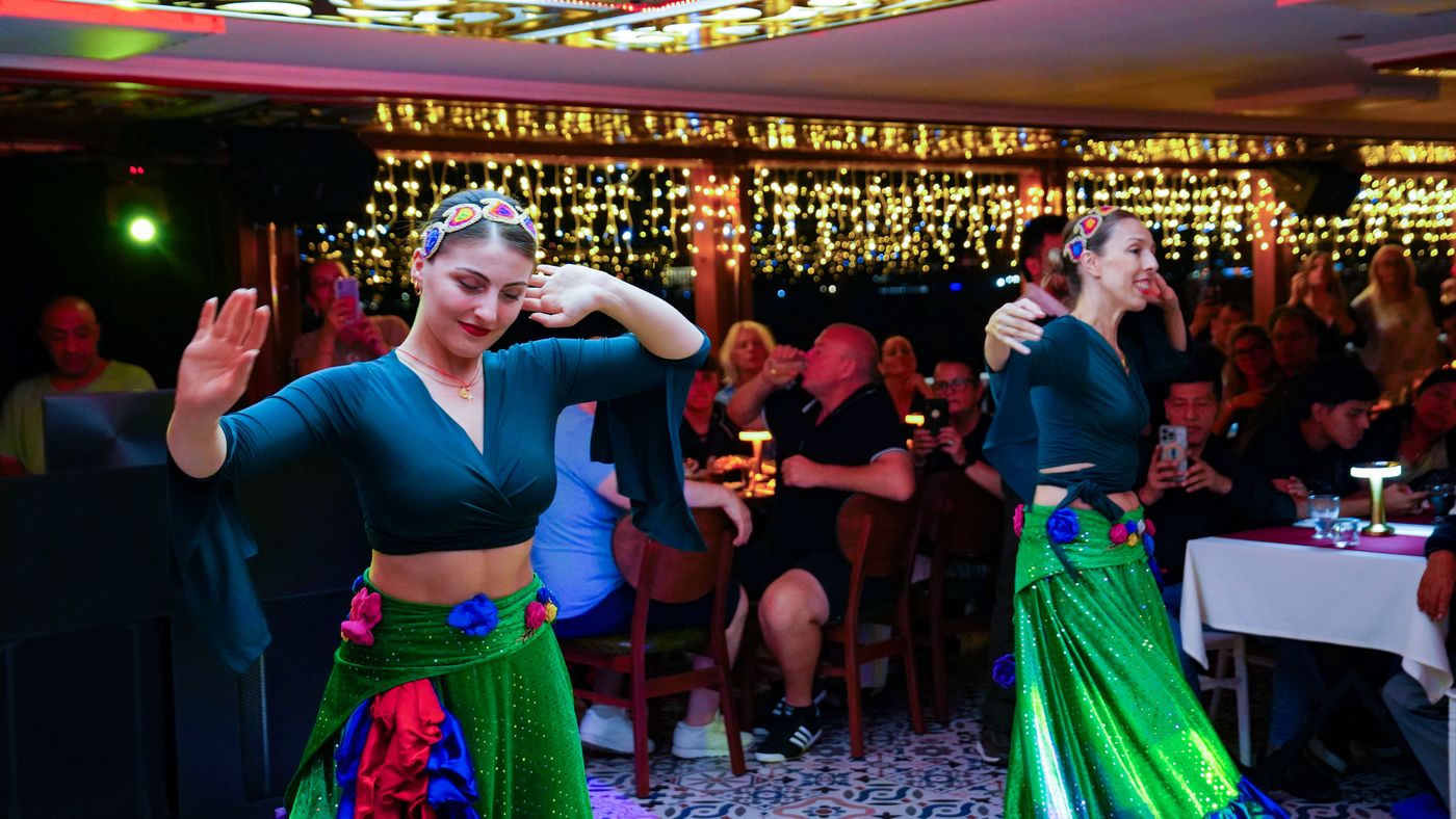 Two dancers in green sequined skirts