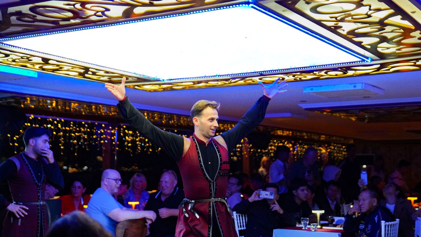 Arms wide, the soloist greets the salon