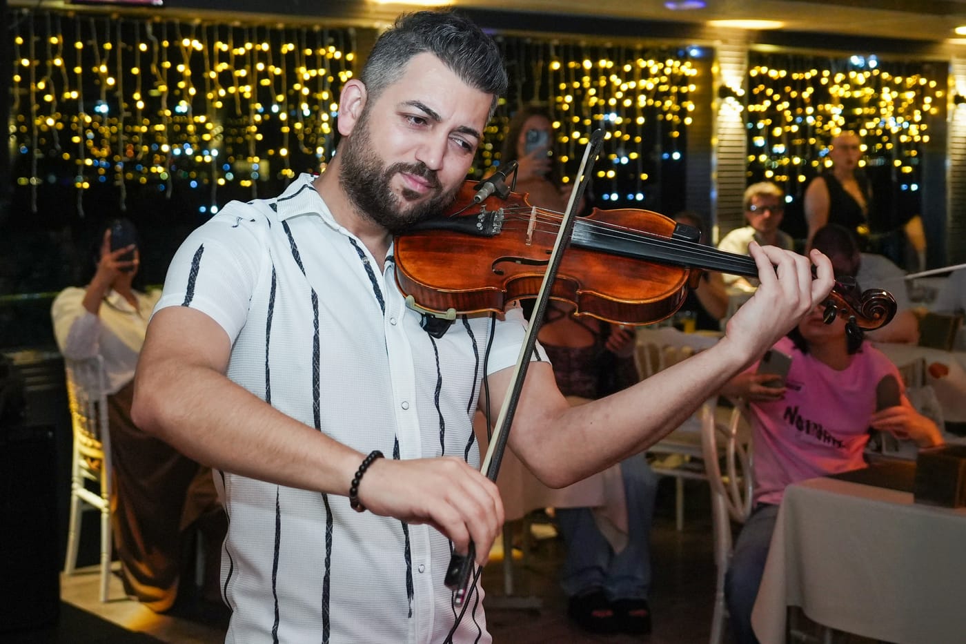 A violinist plays among the guests