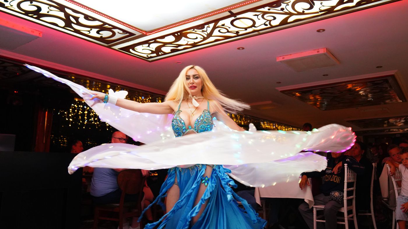Glowing wings sweep across the stage floor