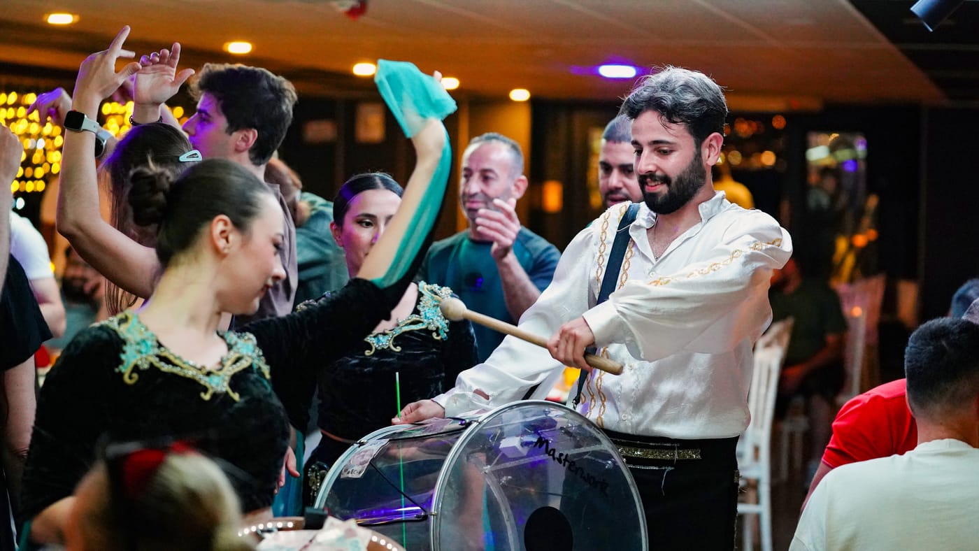 Guests dance around the drummer on the floor