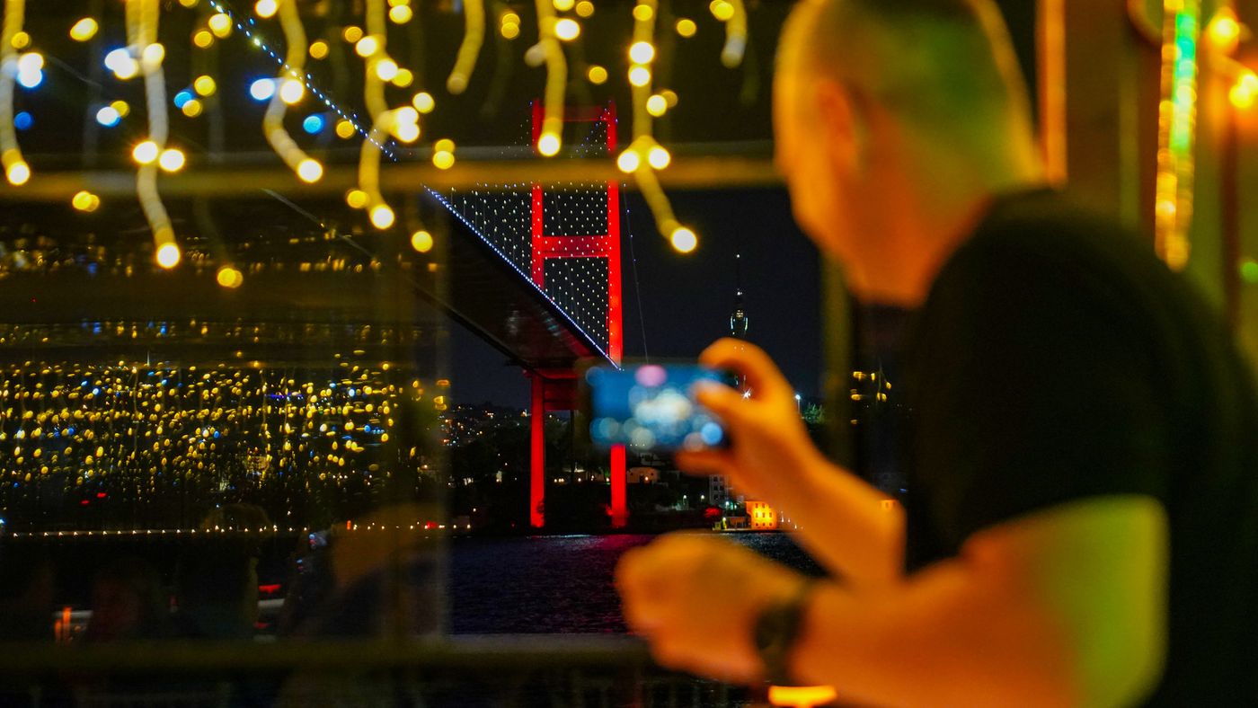 Photographing the lit bridge through the salon window